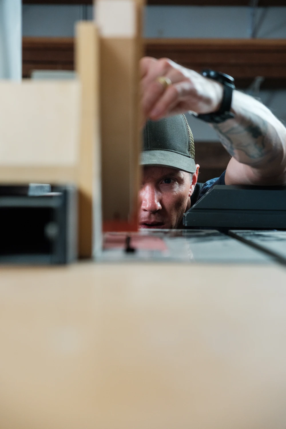 A craftsperson looking along a wooden frame at a workbench.