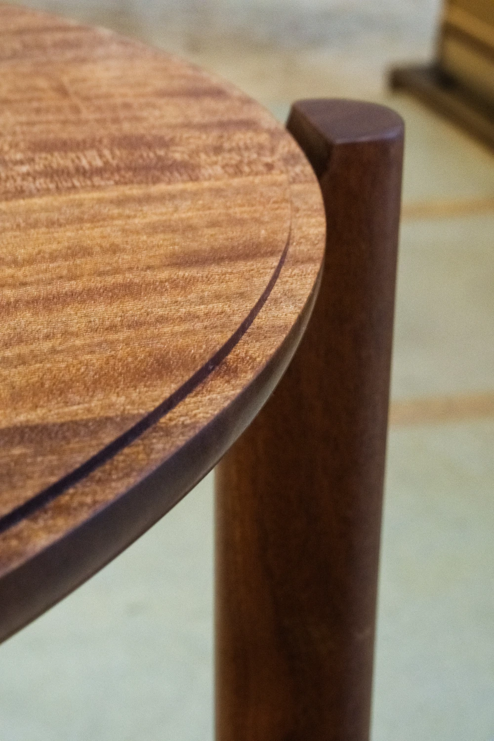 A close view of the joinery and grain in a finished wooden stand.