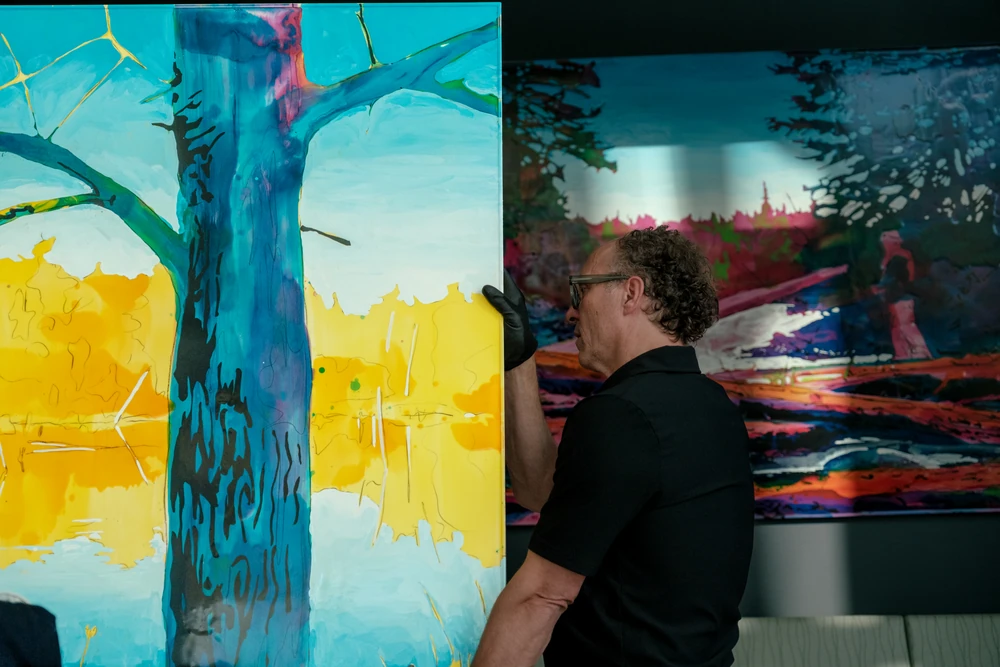 An installer framed by a large, saturated colour artwork.