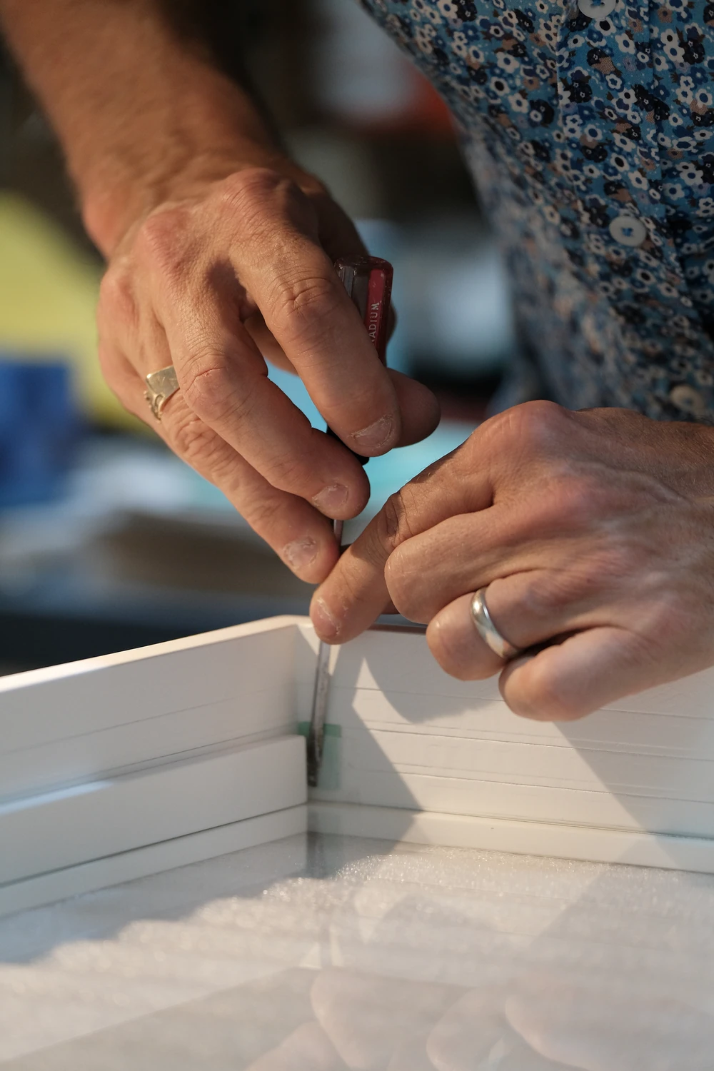 A close view of hands carefully assembling a frame.