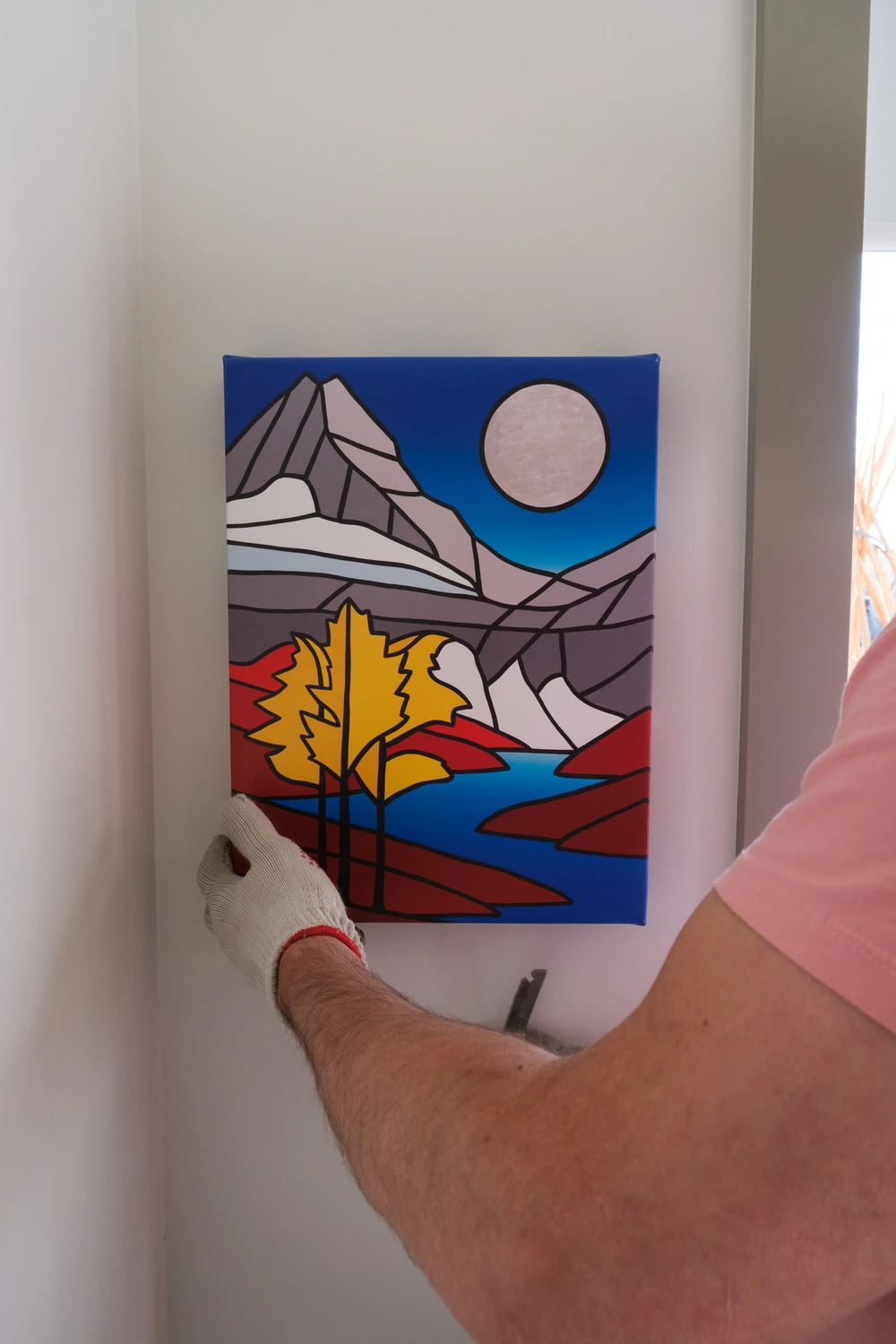Hands holding a level against an artwork.