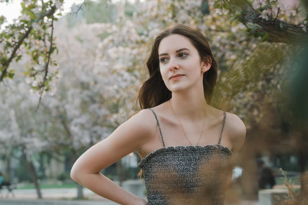 A relaxed portrait framed by soft blossoms.