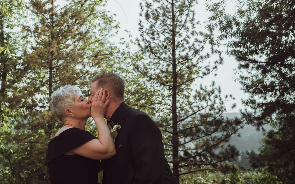 One partner gently touching the other’s face during their wedding.