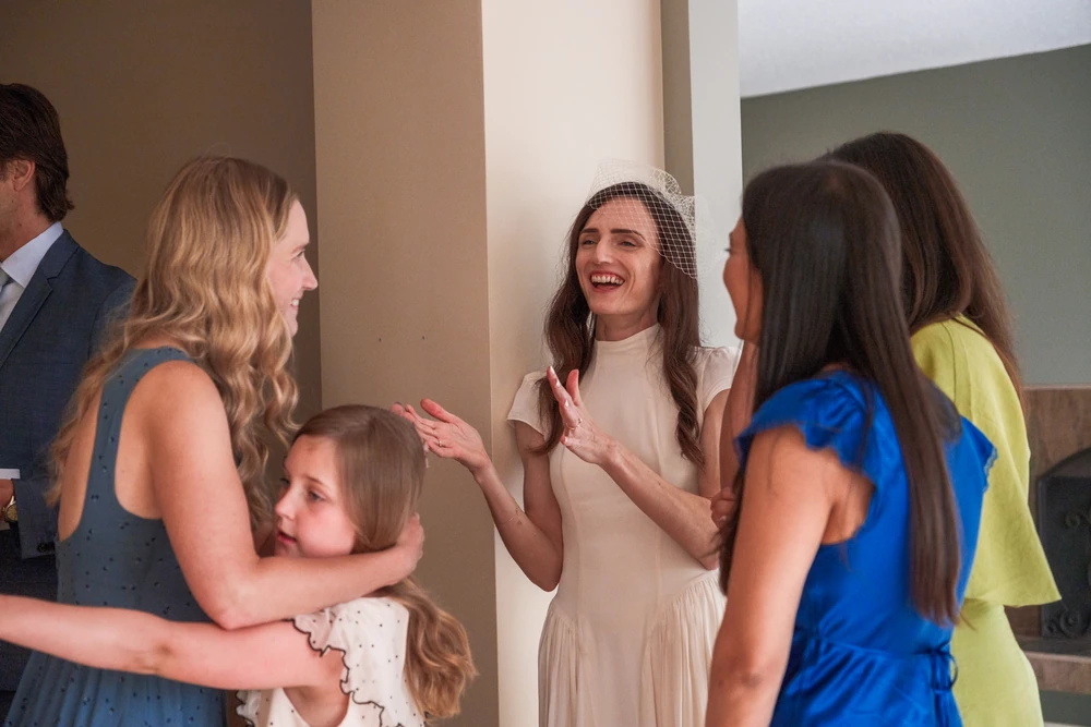 Guests laughing together around a reception table.