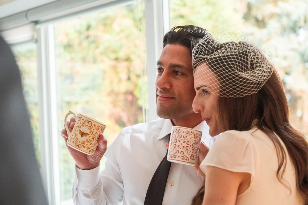 A wedding couple sharing a moment with mugs in their hands.