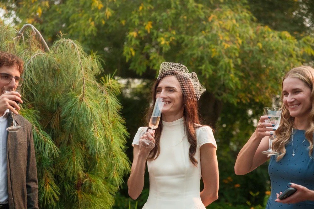 A bride smiling during a wedding toast.