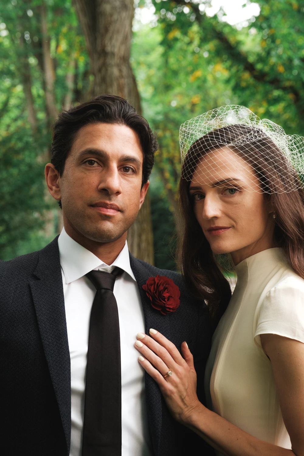 A composed portrait of a wedding couple outdoors.