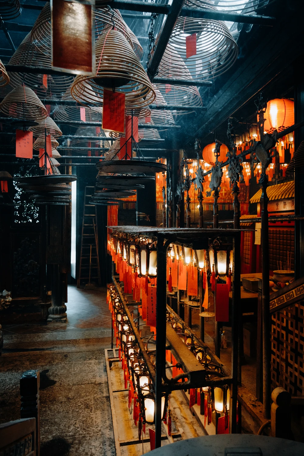 Warm lanterns and hanging incense coils inside a Hong Kong temple.