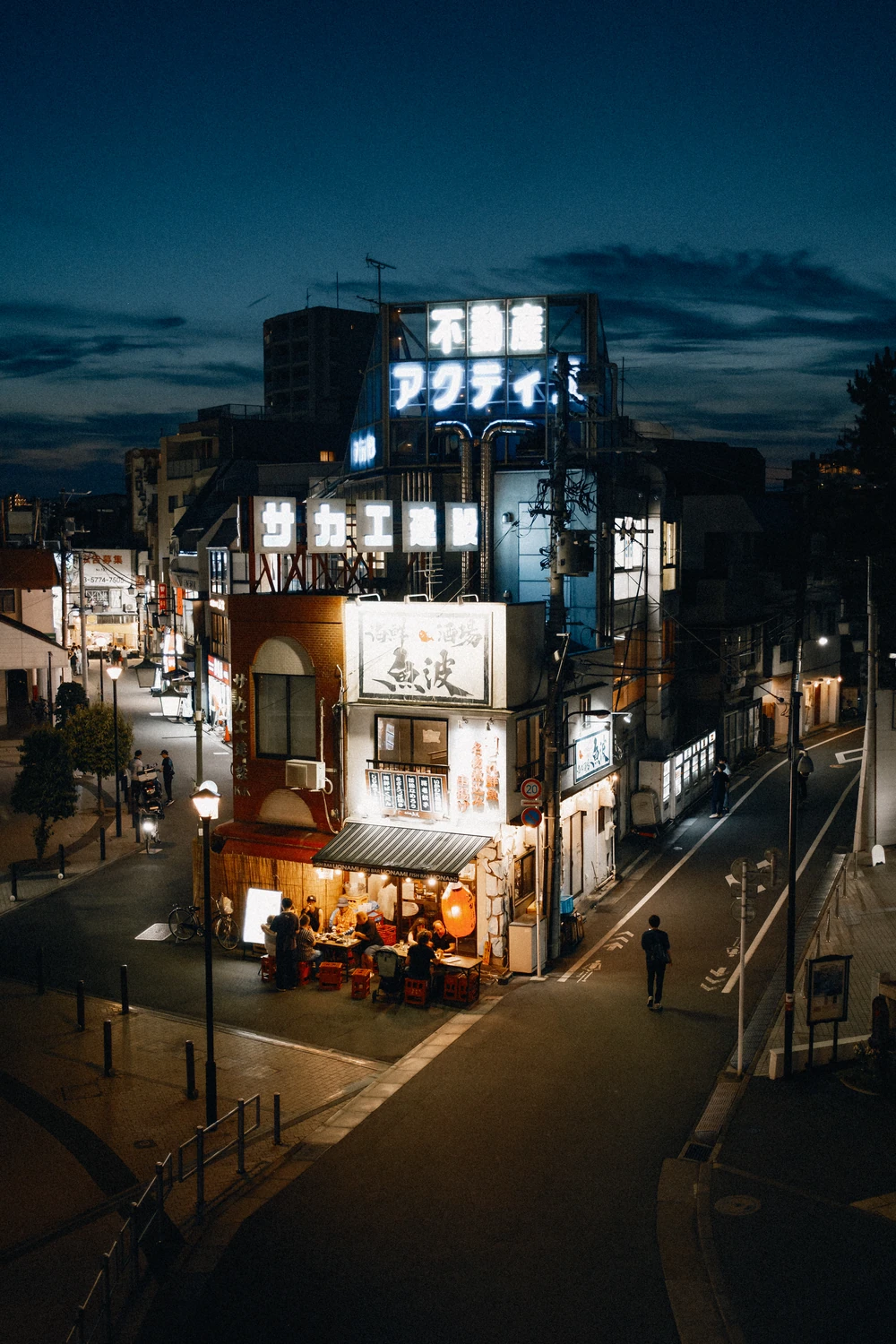 An illuminated corner building in Shiinamachi, Tokyo highlighting the infamous Uonami fish bar