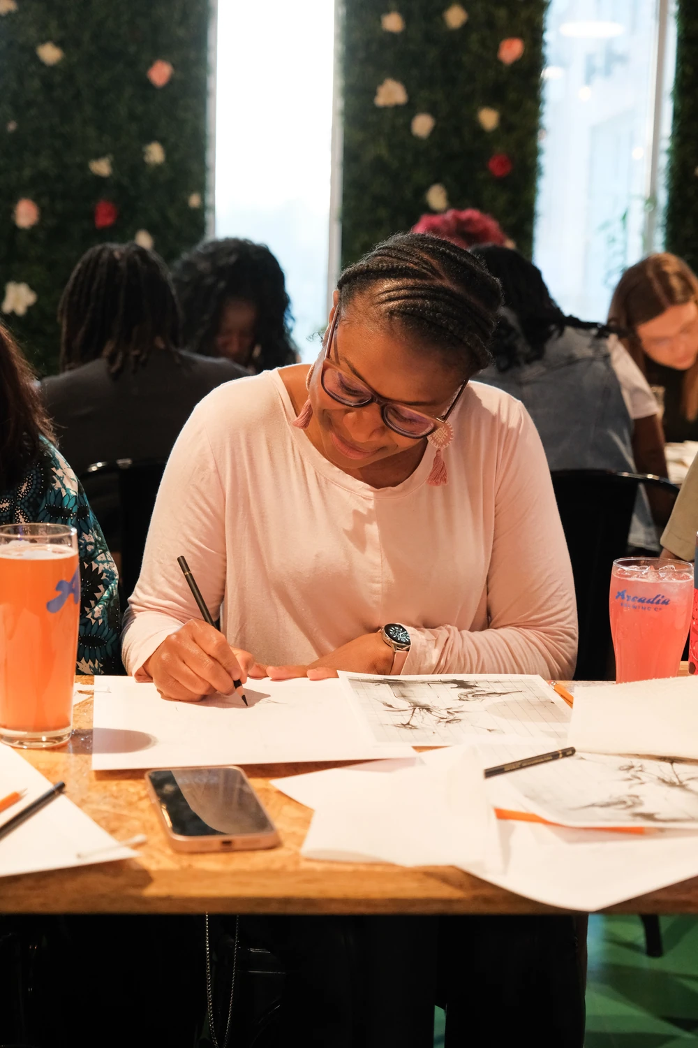 A participant concentrating on her pencil drawing at an Art with Ola workshop.