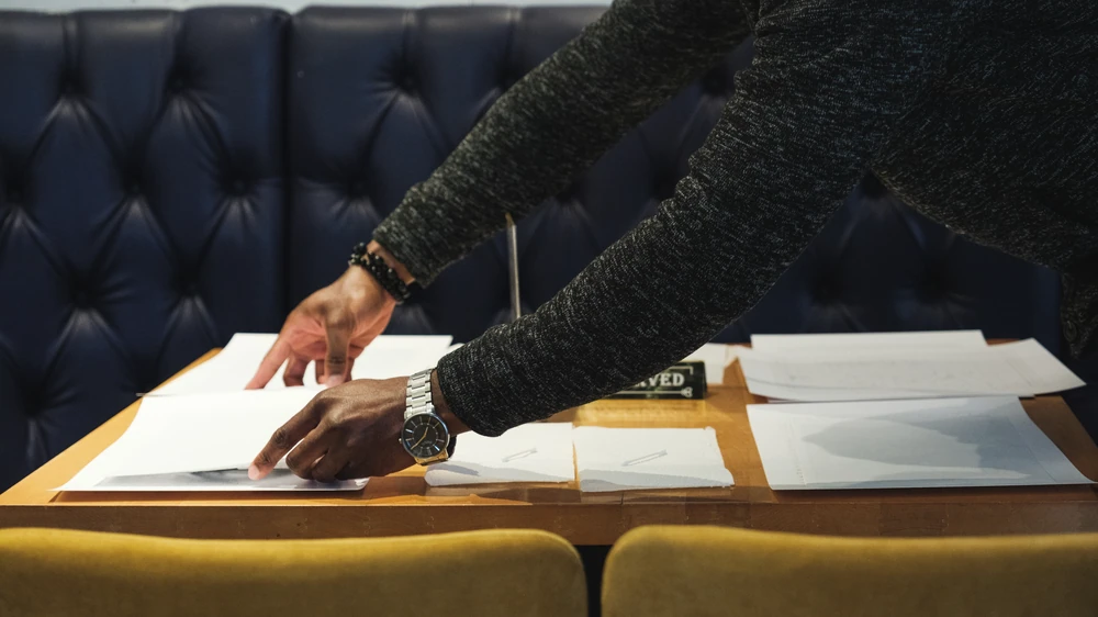 Hands arranging paper and materials on a table before a session.